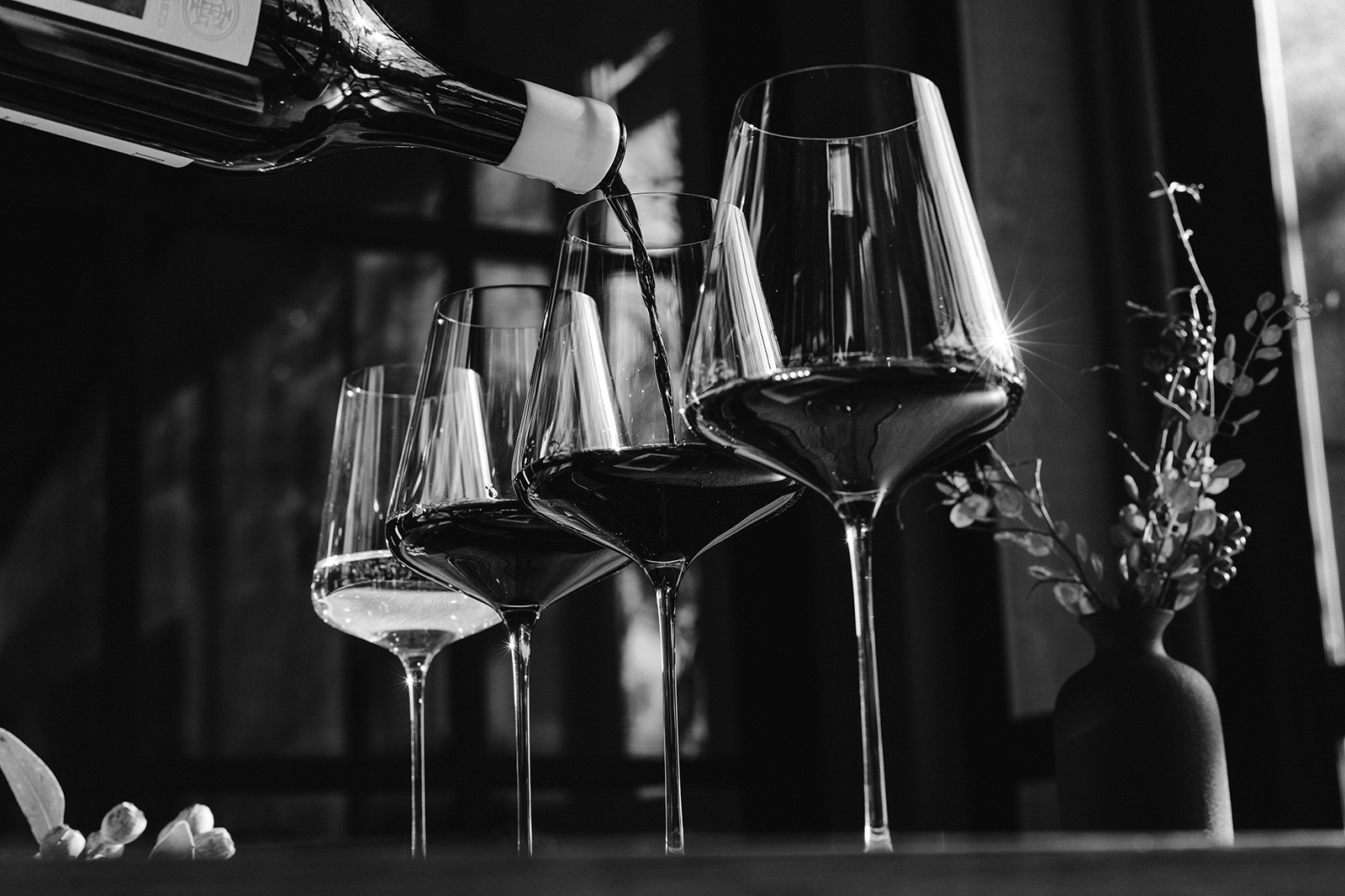A bottle of Ink Grade wine being poured into a glass.